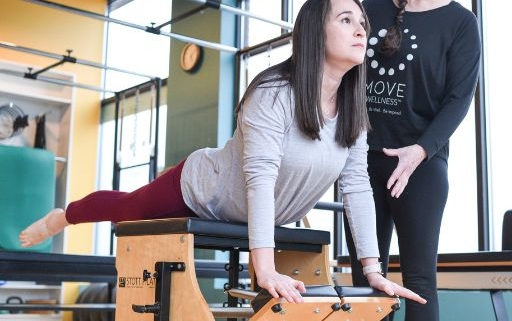 A MOVE Pilates instructor in training learning exercises on the Chair